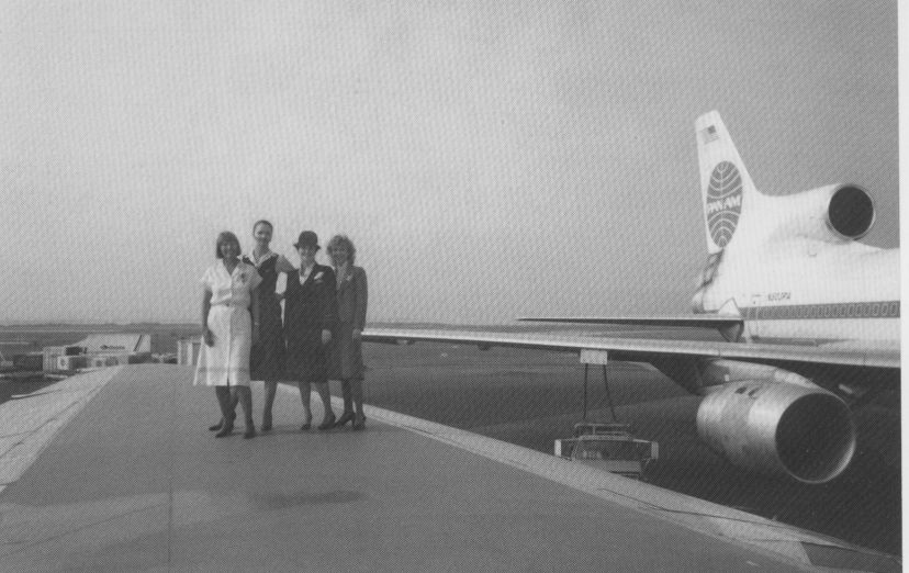 1980s Four Pan Am Flight Attendants pose on the wing of a Lockheed L1011-500.  One Flight Attendant is wearing the summer dress that was available in white & powder blue for several years in the early 1980s.  The uniform was designed by Adolfo and introduced in July of 1980.